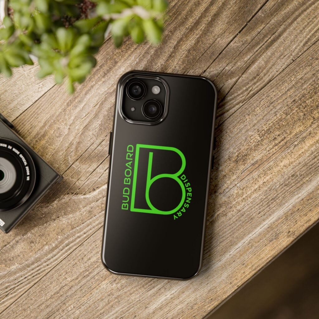 Black iPhone case with Bud Board Dispensary green logo on wooden table.