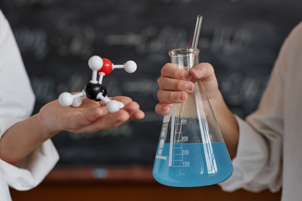 Close-up of scientists holding beakers in a lab, representing cannabis research and how it affects the brain and body.