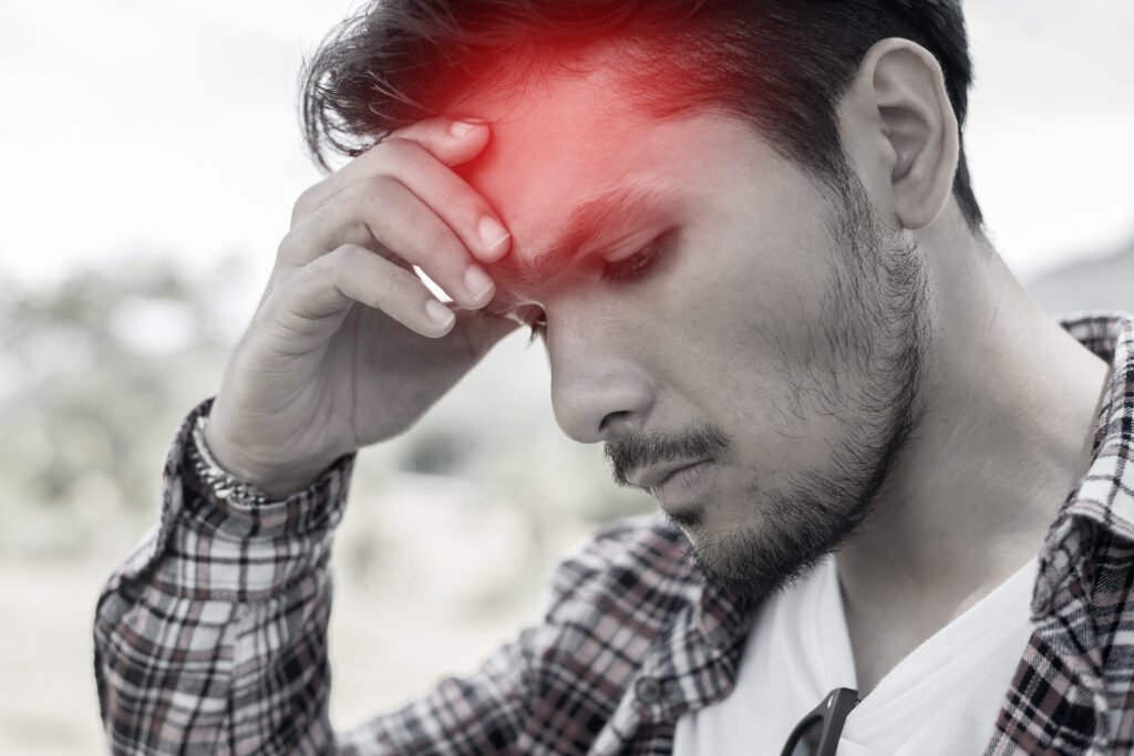 Man holding his head in pain, representing how cannabis may help with discomfort and tension.
