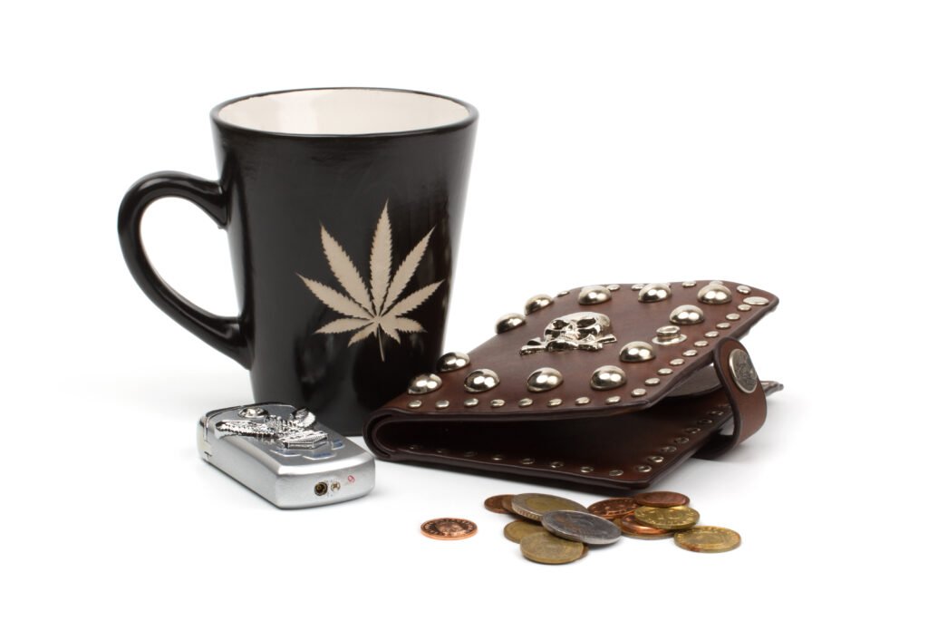 Black cannabis-themed mug with chocolates and decorative rock on white background